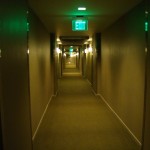 a hallway with a green sign