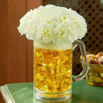 a glass of beer with flowers in it