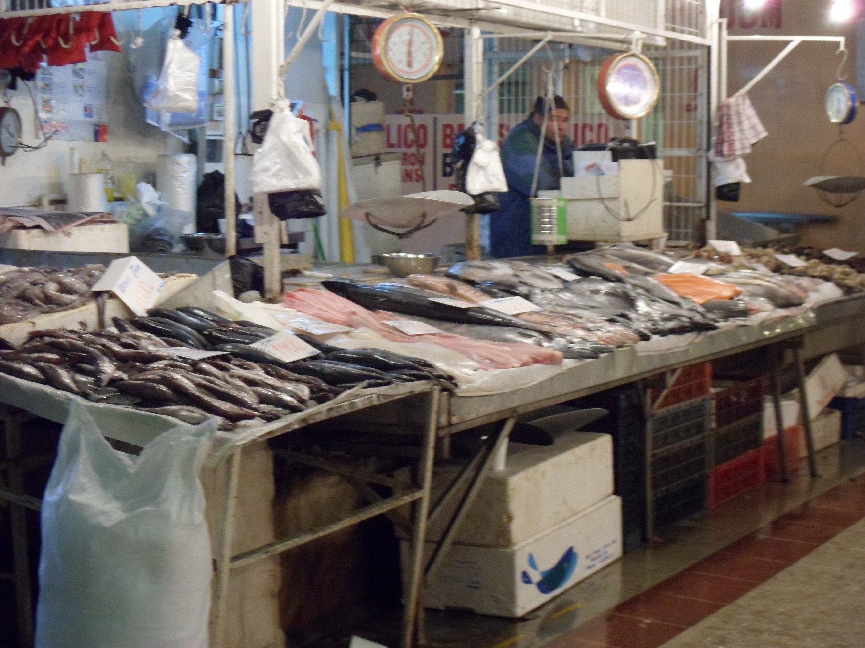 a fish market with a man standing in front of it