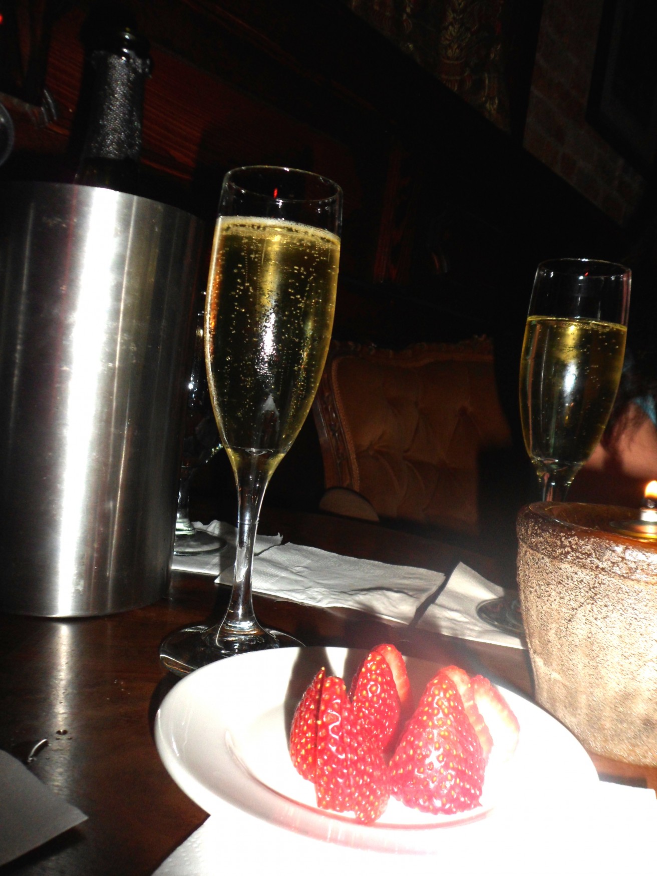 a couple of champagne glasses with strawberries on a table