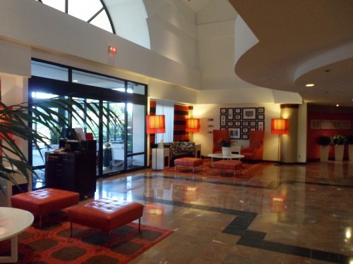 a lobby with red chairs and red lamps