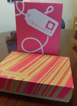 a pink and gold box with a white tag on it