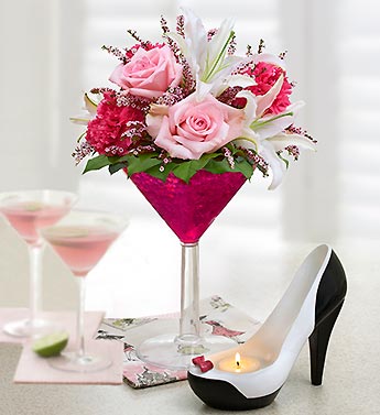 a glass with pink flowers and a pair of shoes