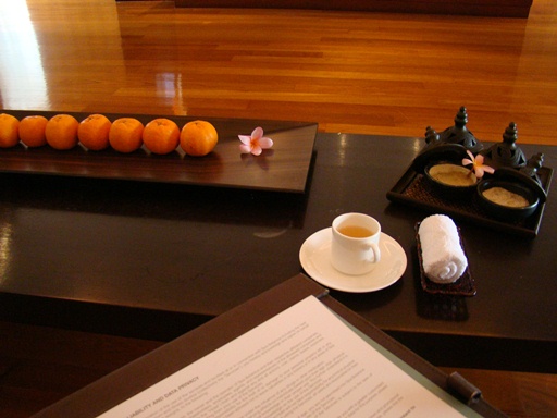 a coffee cup and oranges on a table