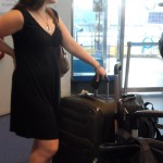 a woman in a black dress with luggage
