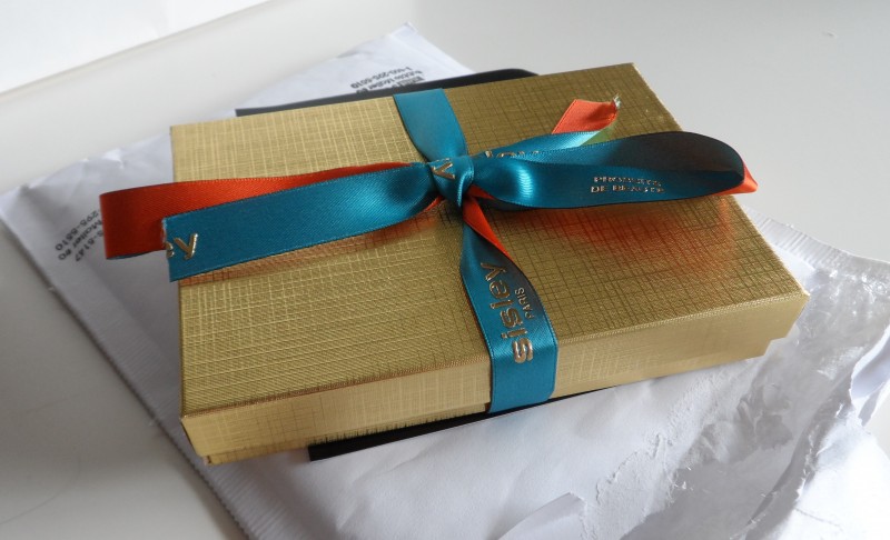 a gold box with a blue and orange ribbon