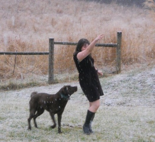 a woman and a dog in the snow