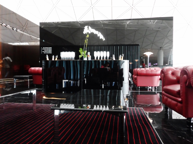 a black and red lounge area with red chairs and a black counter