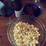 a bowl of popcorn and grapes on a table