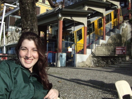 a woman smiling in front of a yellow and yellow train