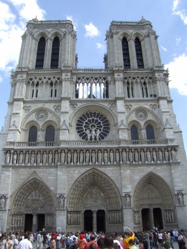 a large white building with towers with Notre Dame de Paris in the background