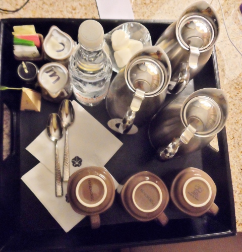a tray with coffee cups and a bottle of water