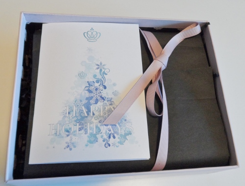 a white card with a pink ribbon in a box