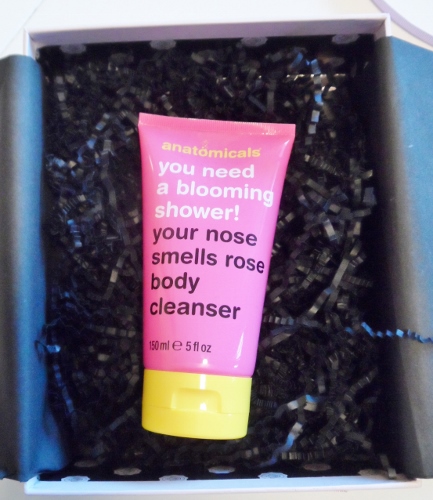 a pink tube of body wash in a box