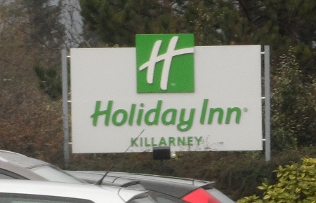 a sign board with green and white text
