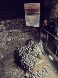 a group of people standing in a room with a pile of rocks