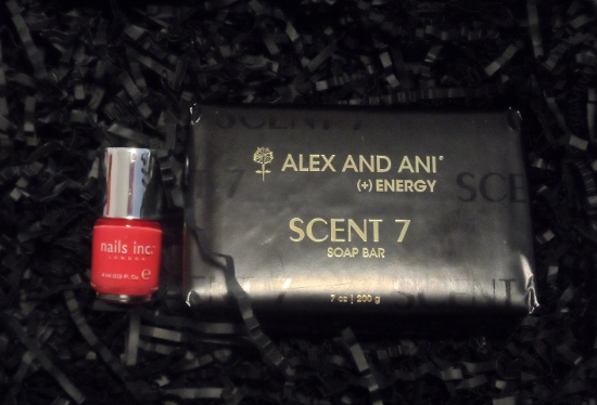 a black package with a red nail polish and a bottle of nail polish