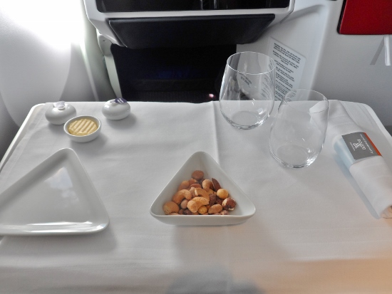 a plate of nuts and wine glasses on a table