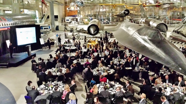 a group of people sitting at tables in a room with airplanes