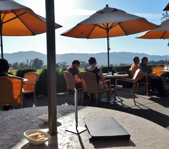 a group of people sitting at tables under umbrellas