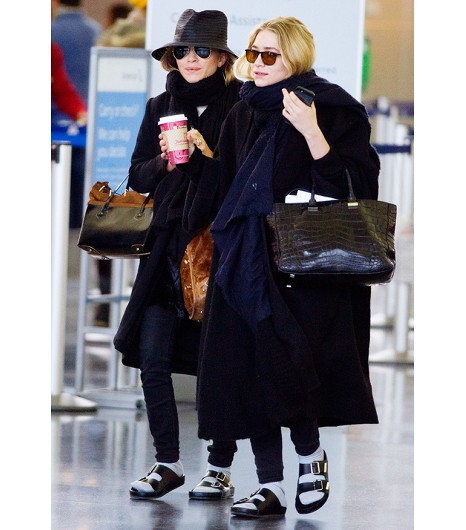 a couple of women wearing black coats and sunglasses