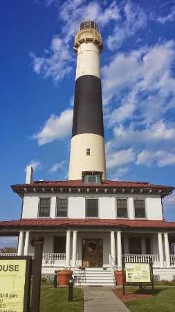 a lighthouse with a blue sky with Absecon Lighthouse in the background