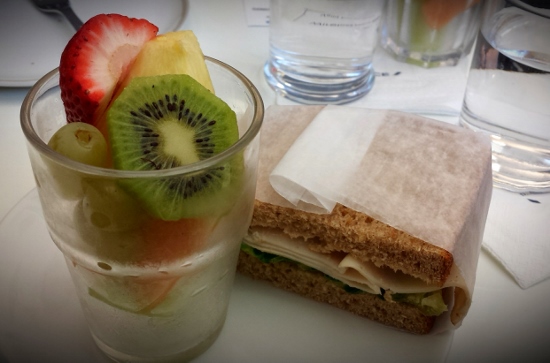 a sandwich and fruit in a glass