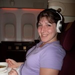 a woman wearing headphones and sitting in an airplane