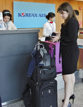 a woman standing next to a stack of luggage