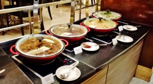 a row of bowls of food on a counter