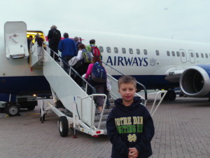 a boy standing in front of a plane