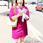 a woman in a pink dress holding white paper towels