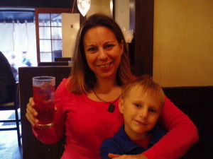 a woman holding a glass of juice and a boy