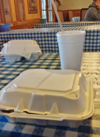 a white foam food container and a cup with a straw