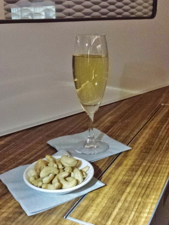 a glass of wine and a plate of nuts