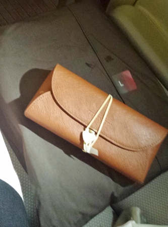 a brown purse with a white tag on it