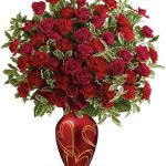 a vase full of red roses