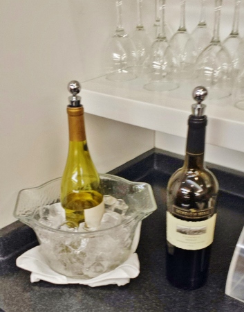 a bottle of wine in a bowl and a glass of wine
