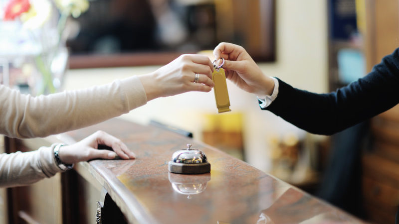 a person handing over a key to a receptionist