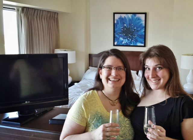 two women holding wine glasses in a hotel room