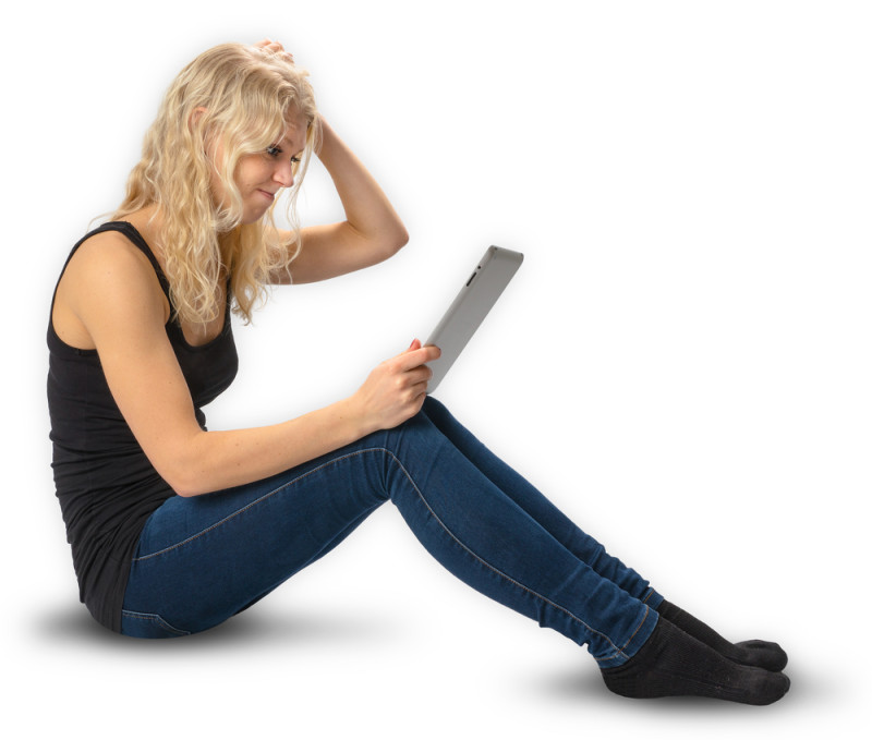 a woman sitting on the floor holding a tablet
