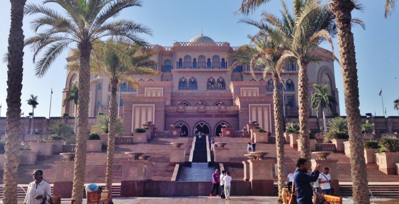 a building with a fountain and palm trees