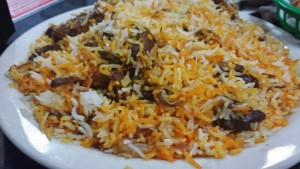 a plate of rice with meat and vegetables