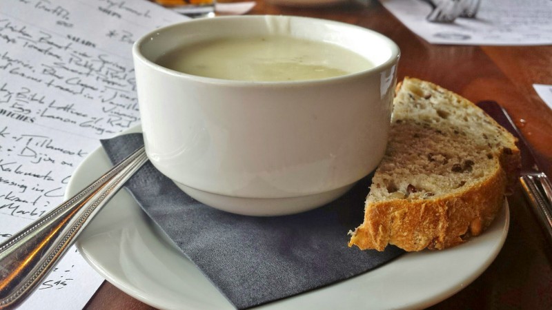 a bowl of soup and a piece of bread on a plate