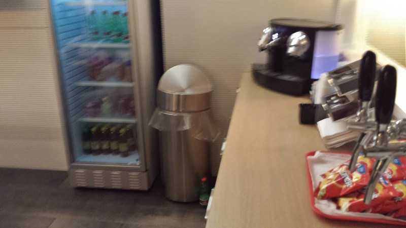 a refrigerator with a drink dispenser and a trash can