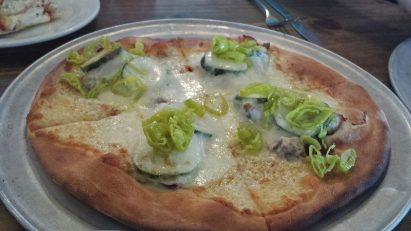 a pizza with cheese and vegetables on a plate