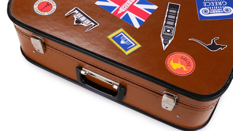 a brown suitcase with stickers on it