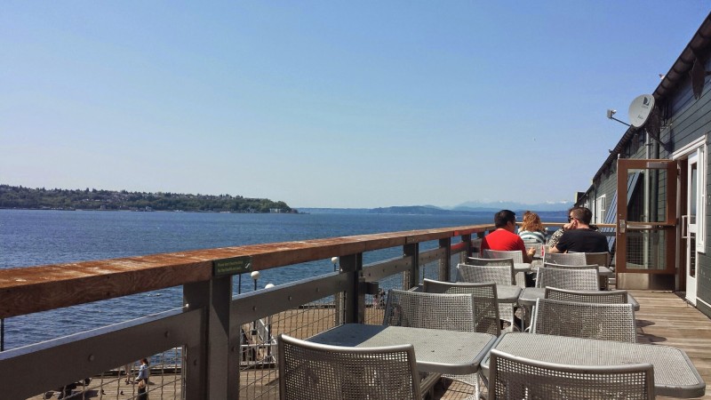 a group of people sitting at a table overlooking a body of water