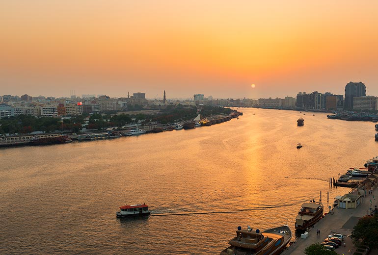 a river with boats in it and a city in the background