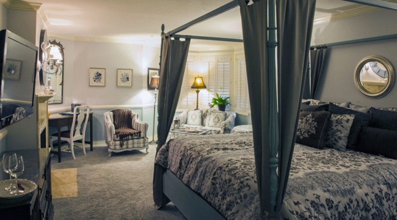 a bedroom with a four poster bed and a chair
